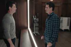Robbie Amell looks at a copy of himself in a mirror in Upload